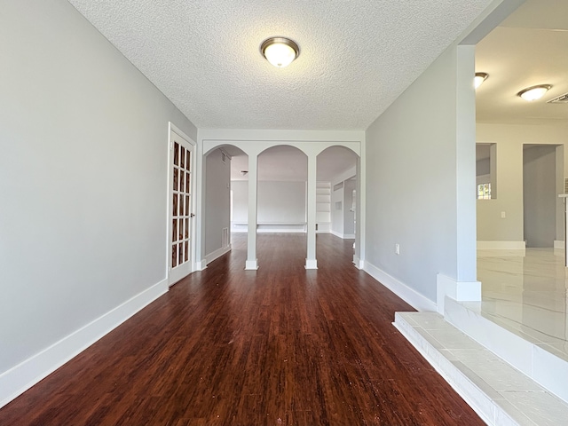 307 4th St, Lake Park, FL 33403 - spare room with arched walkways, wood finished floors, a textured ceiling, and baseboards