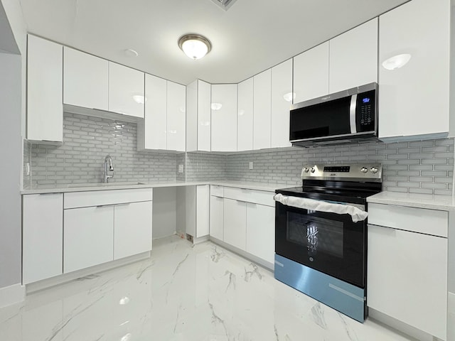 307 4th St, Lake Park, FL 33403 - kitchen with stainless steel appliances, a sink, light marble finish flooring, and decorative backsplash