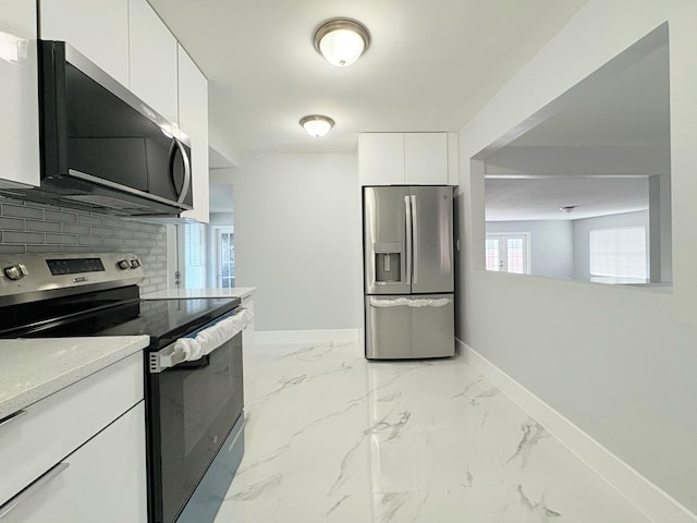 307 4th St, Lake Park, FL 33403 - kitchen with appliances with stainless steel finishes, baseboards, white cabinets, decorative backsplash, and marble finish flooring