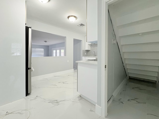 307 4th St, Lake Park, FL 33403 - hallway with light marble finish floors, baseboards, and a sink