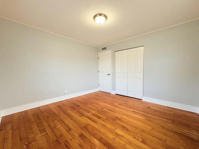 307 4th St, Lake Park, FL 33403 - unfurnished bedroom featuring light wood-style floors, baseboards, and a closet
