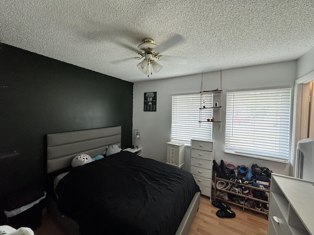 8700 NW 46th Ct, Lauderhill, FL 33351 - bedroom with light wood finished floors, a textured ceiling, and ceiling fan