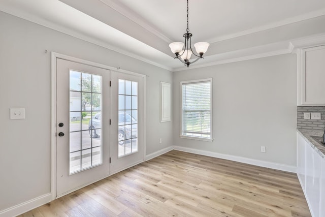 3322 Monterey Square Ln Unit 104, Fort Pierce, FL 34982 - unfurnished dining area with healthy amount of natural light, a chandelier, light wood finished floors, baseboards, and crown molding