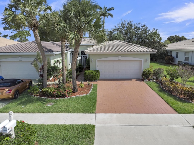 10664 Royal Caribbean Cir, Boynton Beach, FL 33437 - view of front of house featuring a front lawn, stucco siding, a tile roof, and driveway