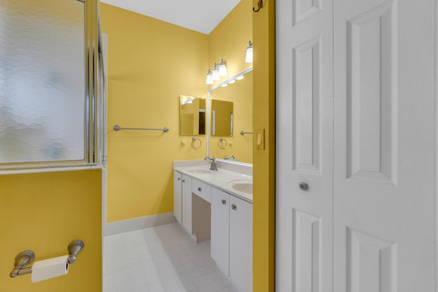 10664 Royal Caribbean Cir, Boynton Beach, FL 33437 - bathroom featuring double vanity, tile patterned flooring, and baseboards