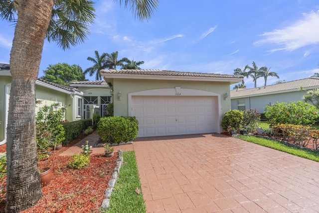 10664 Royal Caribbean Cir, Boynton Beach, FL 33437 - mediterranean / spanish-style house with stucco siding, a garage, decorative driveway, and a tile roof