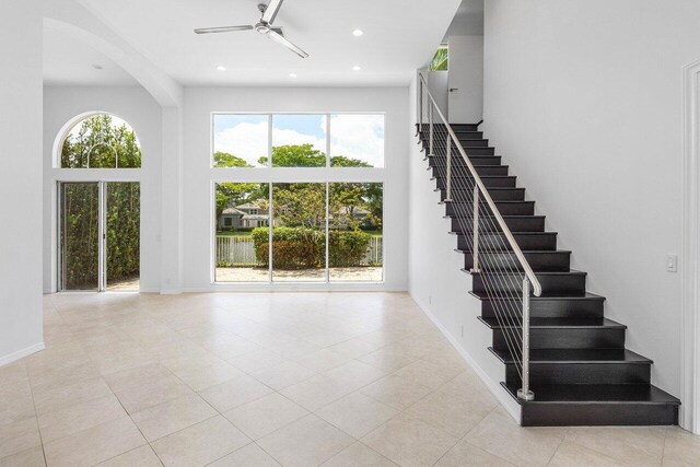 5779 Regency Cir W, Boca Raton, FL 33496 - staircase featuring ceiling fan, a towering ceiling, arched walkways, recessed lighting, and tile patterned flooring