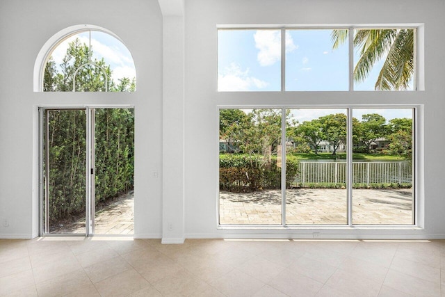 5779 Regency Cir W, Boca Raton, FL 33496 - doorway to outside featuring a towering ceiling, baseboards, and tile patterned floors