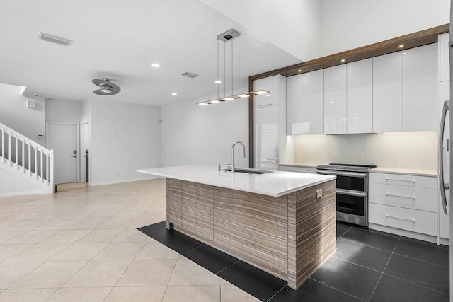 5779 Regency Cir W, Boca Raton, FL 33496 - kitchen with a sink, double oven range, modern cabinets, dark tile patterned flooring, and white cabinetry
