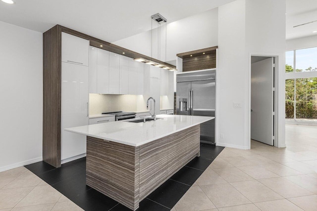 5779 Regency Cir W, Boca Raton, FL 33496 - kitchen with modern cabinets, appliances with stainless steel finishes, a sink, white cabinetry, and a towering ceiling