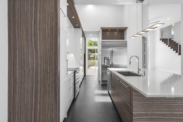 5779 Regency Cir W, Boca Raton, FL 33496 - kitchen with a sink, appliances with stainless steel finishes, modern cabinets, a large island with sink, and dark brown cabinetry
