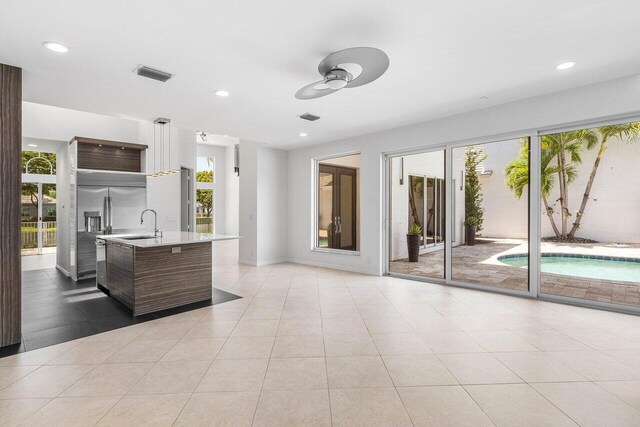 5779 Regency Cir W, Boca Raton, FL 33496 - kitchen with light countertops, a ceiling fan, a sink, an island with sink, and modern cabinets