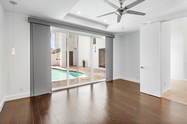 5779 Regency Cir W, Boca Raton, FL 33496 - spare room featuring healthy amount of natural light, wood finished floors, ceiling fan, a tray ceiling, and recessed lighting