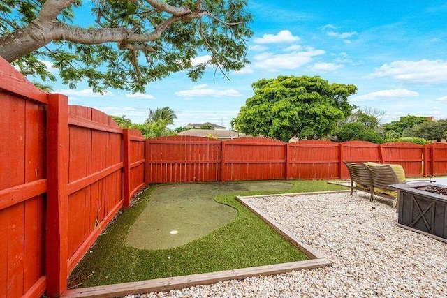 803 Mallard Dr, Delray Beach, FL 33444 - fenced backyard with a putting green and a fire pit