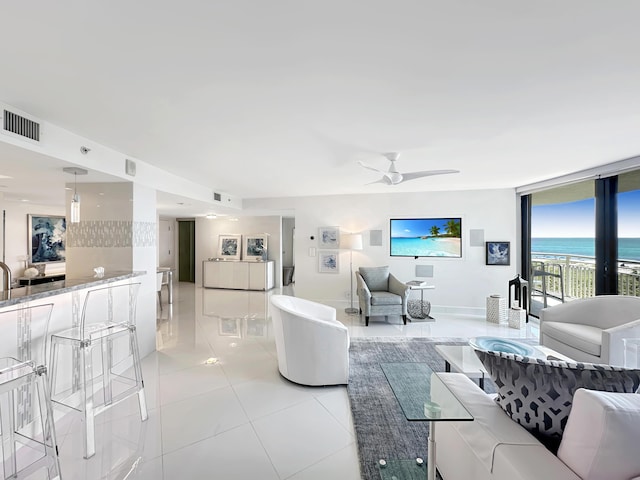 3000 N Ocean Dr Unit 4-D, Singer Island, FL 33404 - living room featuring a ceiling fan, light tile patterned flooring, floor to ceiling windows, and baseboards