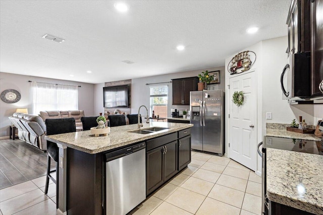 3313 SW Ludlow St, Port Saint Lucie, FL 34953 - kitchen featuring appliances with stainless steel finishes, a sink, open floor plan, a kitchen island with sink, and a breakfast bar area