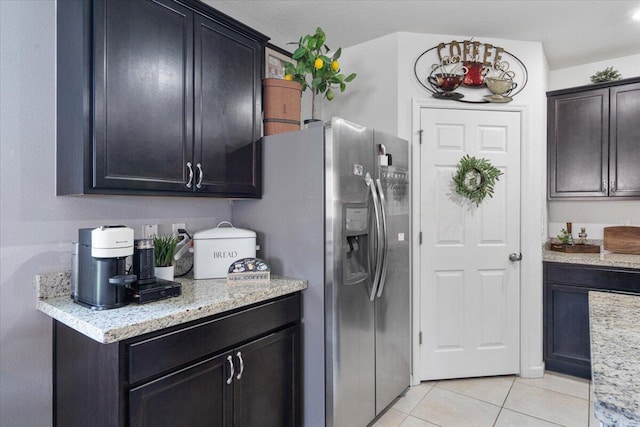 3313 SW Ludlow St, Port Saint Lucie, FL 34953 - kitchen featuring light tile patterned floors, light stone counters, and stainless steel fridge with ice dispenser