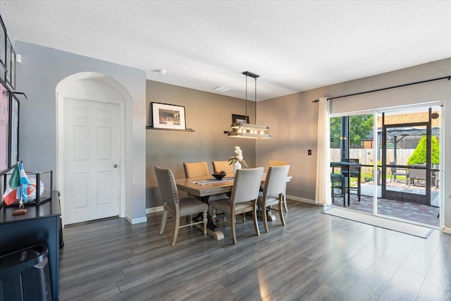 3313 SW Ludlow St, Port Saint Lucie, FL 34953 - dining space with baseboards, wood finished floors, arched walkways, and a textured ceiling