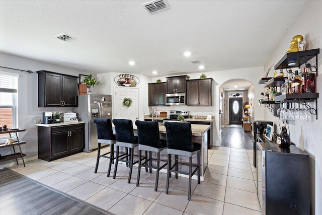 3313 SW Ludlow St, Port Saint Lucie, FL 34953 - dining space with arched walkways, a textured ceiling, recessed lighting, and light tile patterned floors