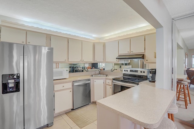 331 Knotty Pine Cir Unit C-1, Greenacres, FL 33463 - kitchen with stainless steel appliances, under cabinet range hood, a sink, a peninsula, and light countertops