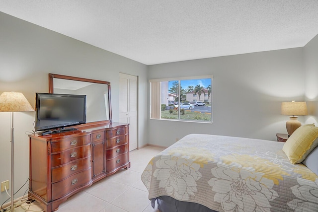 331 Knotty Pine Cir Unit C-1, Greenacres, FL 33463 - bedroom with light tile patterned floors, a closet, a textured ceiling, and baseboards