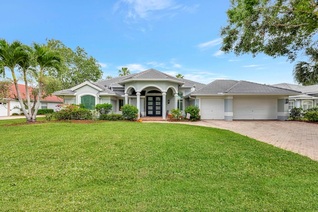 2703 SW Glenmoor Way, Palm City, FL 34990 - ranch-style house featuring french doors, a garage, a front yard, and stucco siding