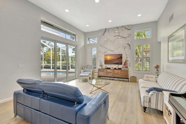 2703 SW Glenmoor Way, Palm City, FL 34990 - living area featuring recessed lighting, light wood finished floors, a towering ceiling, and baseboards