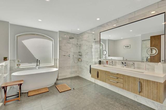 2703 SW Glenmoor Way, Palm City, FL 34990 - bathroom featuring a soaking tub, tile walls, a tile shower, double vanity, and tile patterned floors