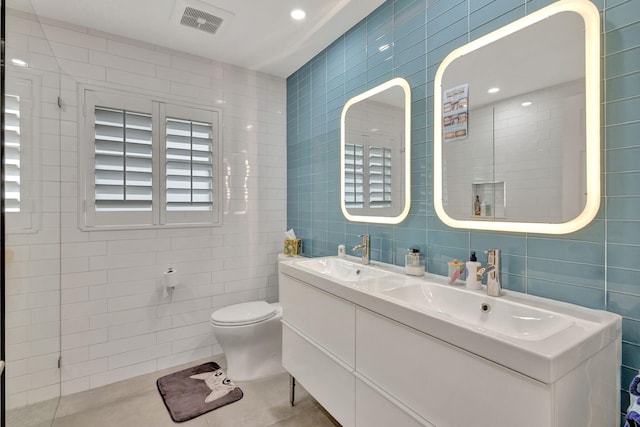 2703 SW Glenmoor Way, Palm City, FL 34990 - bathroom featuring tile walls, double vanity, tile patterned floors, and toilet