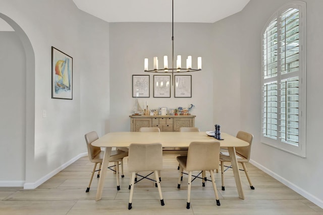 2703 SW Glenmoor Way, Palm City, FL 34990 - dining area featuring arched walkways, baseboards, a chandelier, and light wood-style floors