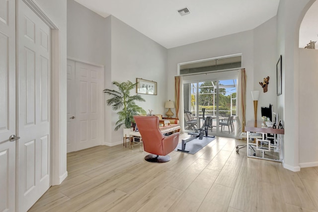 2703 SW Glenmoor Way, Palm City, FL 34990 - living area featuring arched walkways, light wood finished floors, and baseboards