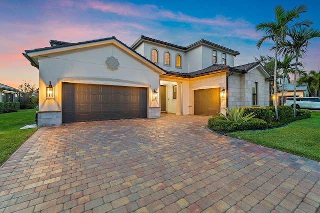 515 Sonoma Isles Cir, Jupiter, FL 33478 - mediterranean / spanish-style home featuring an attached garage, decorative driveway, a yard, stucco siding, and a tiled roof