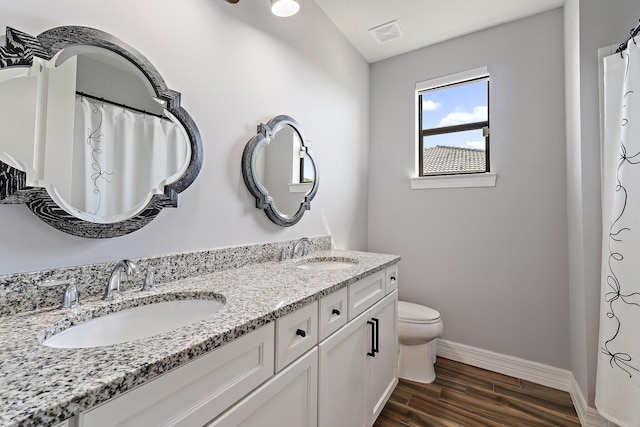 515 Sonoma Isles Cir, Jupiter, FL 33478 - full bathroom with baseboards, double vanity, toilet, and wood finished floors