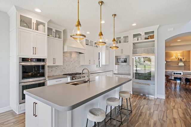 515 Sonoma Isles Cir, Jupiter, FL 33478 - kitchen with built in appliances, arched walkways, wood finished floors, recessed lighting, and tasteful backsplash