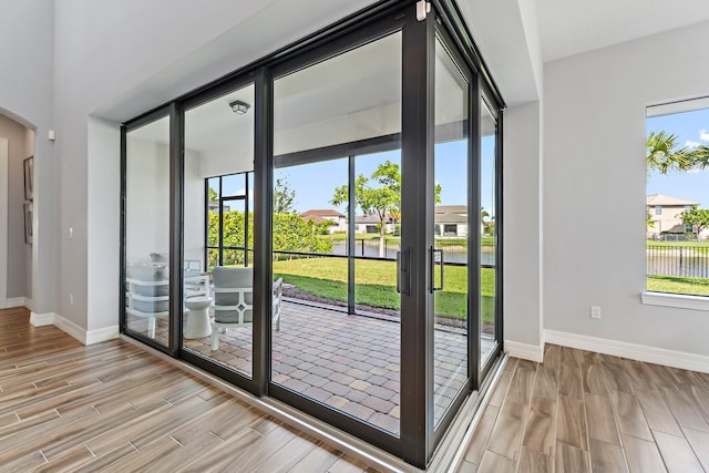 515 Sonoma Isles Cir, Jupiter, FL 33478 - doorway with wood finish floors, baseboards, a water view, and arched walkways