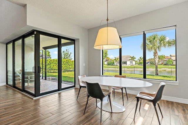515 Sonoma Isles Cir, Jupiter, FL 33478 - dining room featuring baseboards, wood finished floors, and a water view