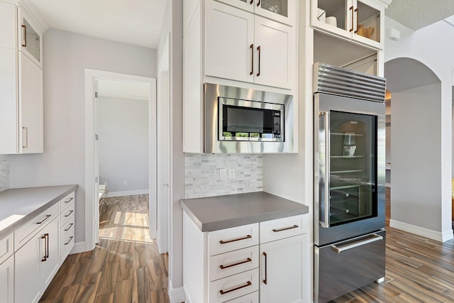 515 Sonoma Isles Cir, Jupiter, FL 33478 - kitchen featuring appliances with stainless steel finishes, dark wood-style floors, backsplash, white cabinetry, and glass insert cabinets