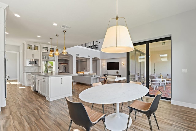 515 Sonoma Isles Cir, Jupiter, FL 33478 - dining room with light wood finished floors, recessed lighting, baseboards, and arched walkways