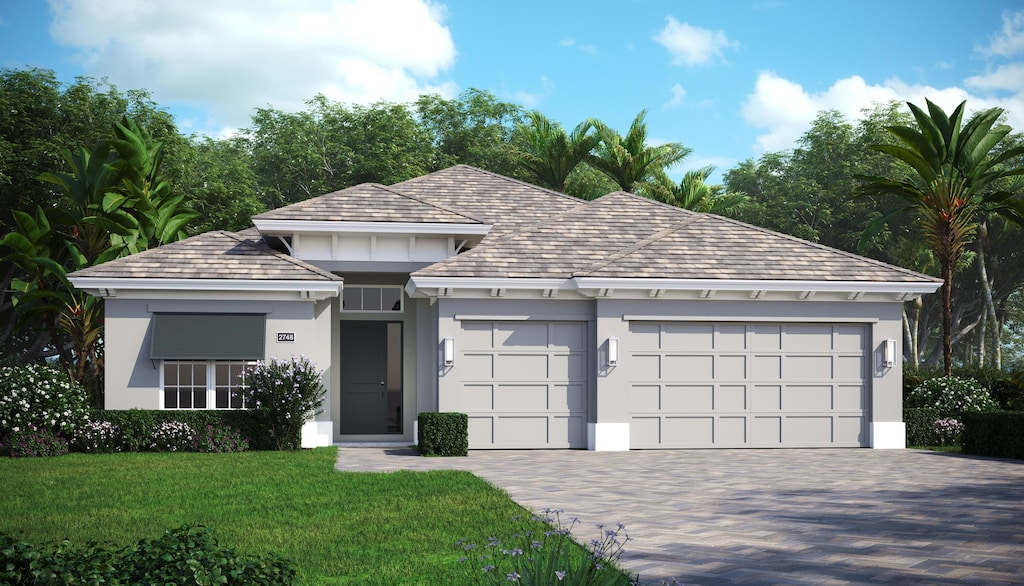 9379 SW Pinnacle Pl N, Port Saint Lucie, FL 34987 - view of front of property with an attached garage, a front lawn, stucco siding, and driveway