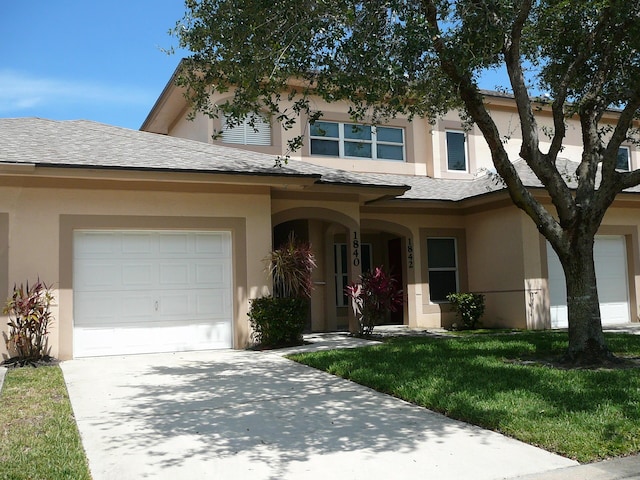 1840 E Sanderling Ln Unit 1, Fort Pierce, FL 34982 - view of front of property with stucco siding, driveway, an attached garage, and a front lawn