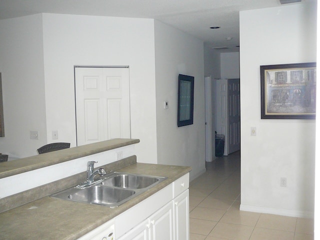 1840 E Sanderling Ln Unit 1, Fort Pierce, FL 34982 - kitchen with a sink, light tile patterned flooring, white cabinetry, and baseboards