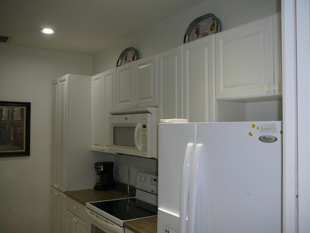 1840 E Sanderling Ln Unit 1, Fort Pierce, FL 34982 - kitchen with white appliances, white cabinetry, recessed lighting, and dark countertops