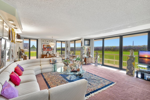 3300 S Ocean Blvd Unit 103S, Palm Beach, FL 33480 - living room featuring a textured ceiling, carpet, floor to ceiling windows, and a chandelier
