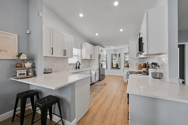 23283 Boca Trace Dr, Boca Raton, FL 33433 - kitchen with appliances with stainless steel finishes, a kitchen breakfast bar, healthy amount of natural light, a peninsula, and recessed lighting