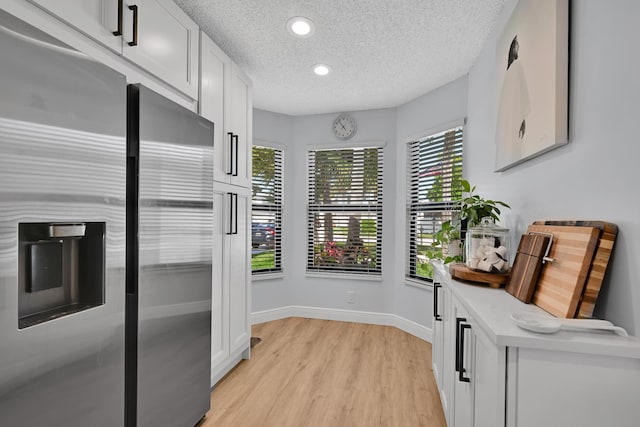 23283 Boca Trace Dr, Boca Raton, FL 33433 - kitchen with stainless steel fridge, a textured ceiling, light wood finished floors, white cabinets, and light countertops
