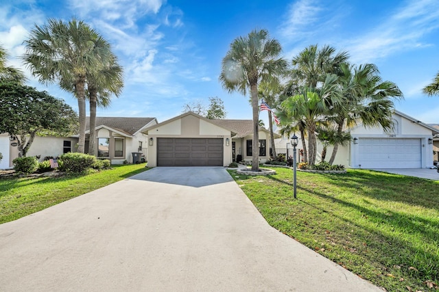 23283 Boca Trace Dr, Boca Raton, FL 33433 - view of front of property with stucco siding, a front lawn, driveway, and an attached garage