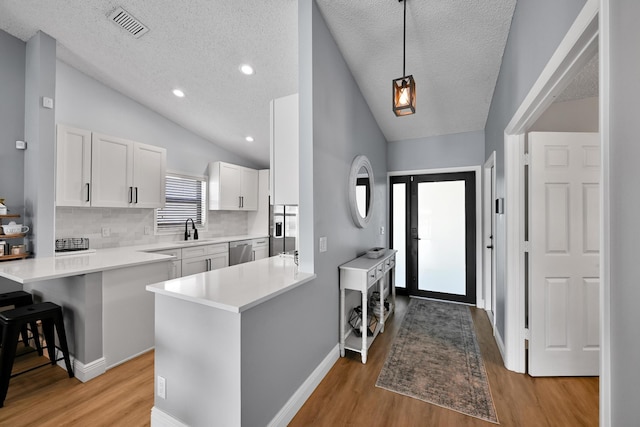 23283 Boca Trace Dr, Boca Raton, FL 33433 - kitchen featuring lofted ceiling, dishwasher, a sink, a peninsula, and a textured ceiling
