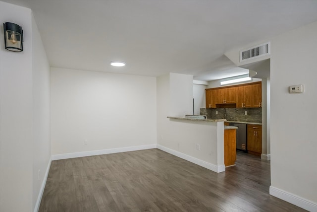 1673 Bay Rd Unit 206, Miami Beach, FL 33139 - kitchen featuring brown cabinets, dark wood-type flooring, backsplash, stainless steel dishwasher, and baseboards
