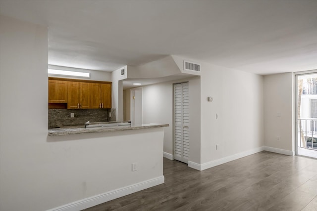 1673 Bay Rd Unit 206, Miami Beach, FL 33139 - kitchen with brown cabinets, backsplash, dark wood-type flooring, and baseboards