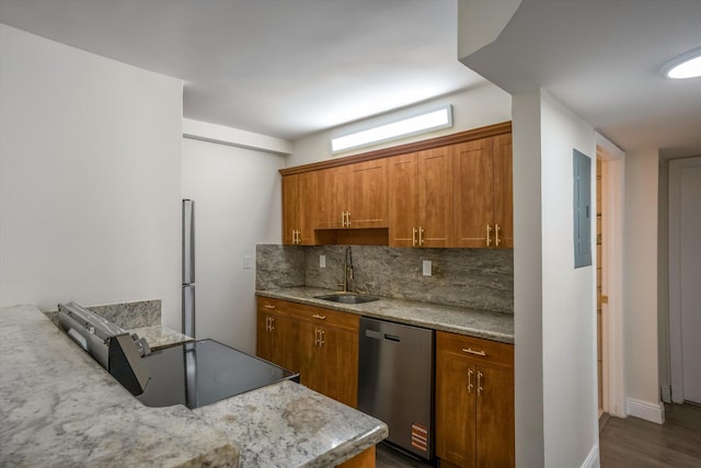 1673 Bay Rd Unit 206, Miami Beach, FL 33139 - kitchen featuring stainless steel appliances, a sink, backsplash, brown cabinets, and dark wood finished floors